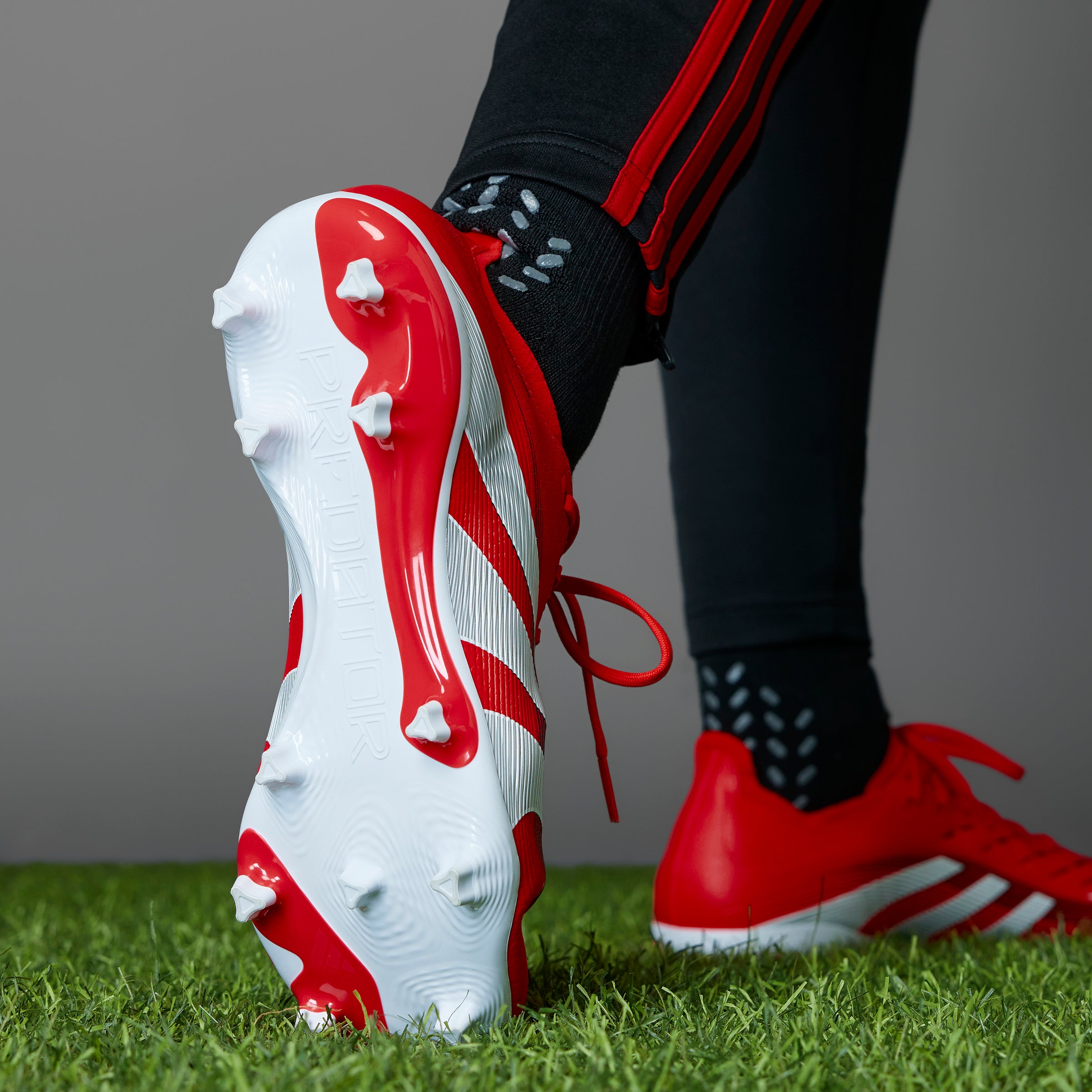 Botas de fútbol para terreno firme y múltiple adidas Predator League, color rojo y blanco